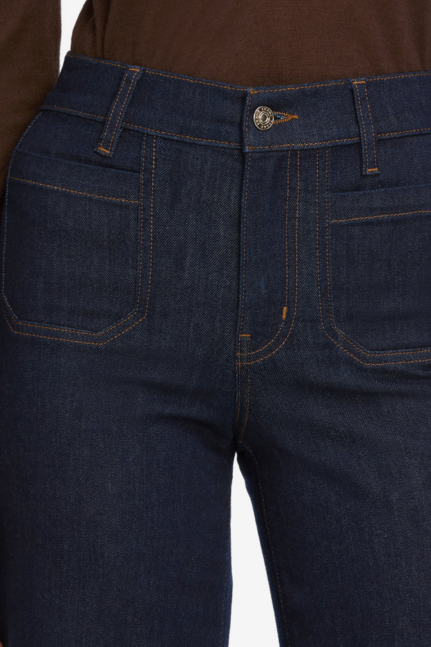 Close-up of dark blue jeans with a white background