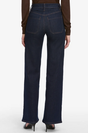 Dark blue jeans worn by a person on a white background