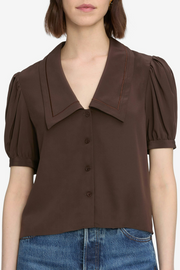 Brown blouse with puff sleeves worn by a person on a white background