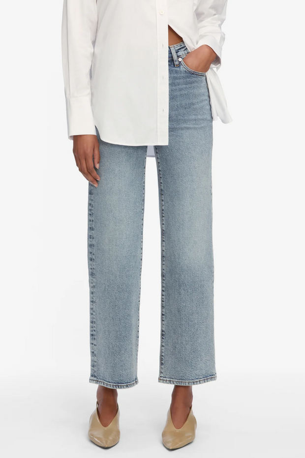 Person wearing light blue jeans and a white shirt on a white background