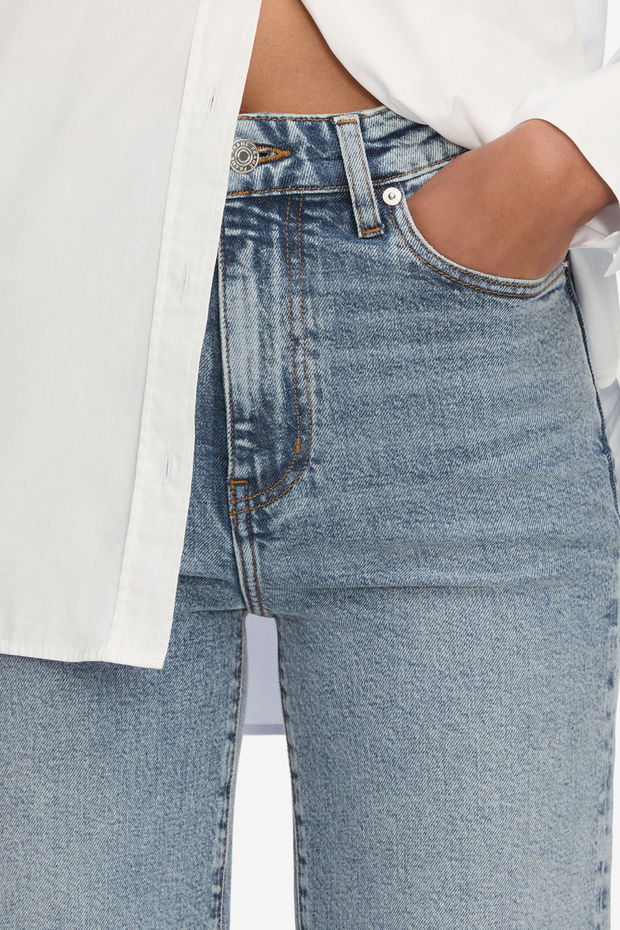 Close-up of blue jeans with a white shirt on a light background