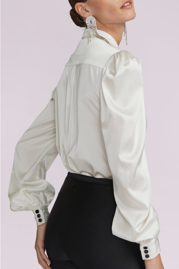 Image of model wearing Generation Love Arly blouse in white with black bows and buttons