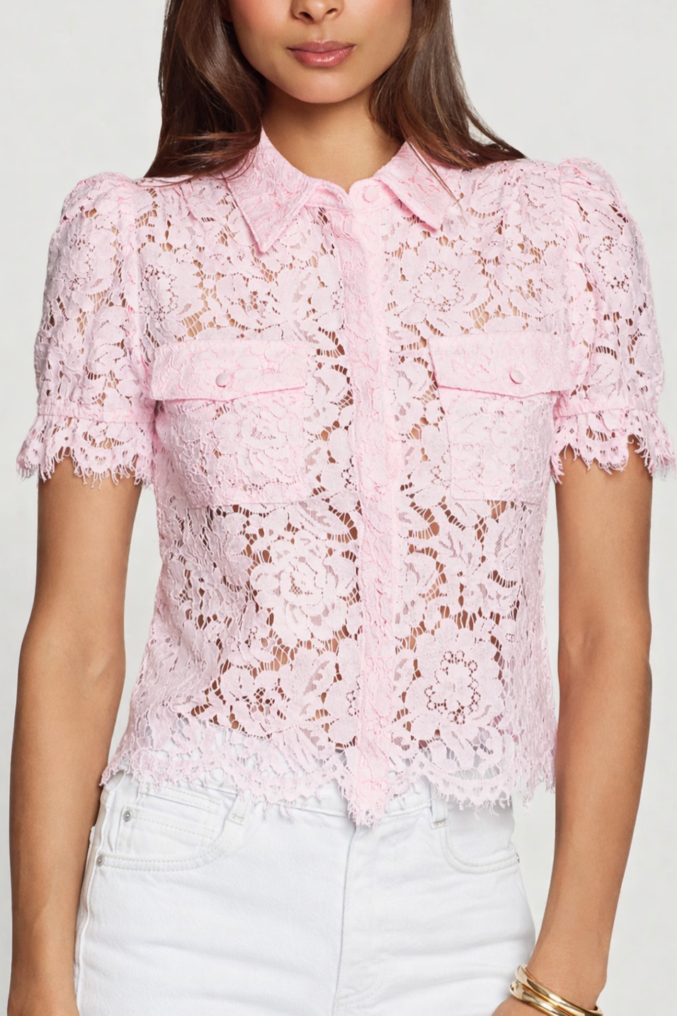 Pink lace blouse worn by a person on a white background
