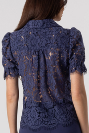Navy lace top worn by a model on a white background
