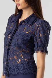 Navy lace top worn by a model on a plain background