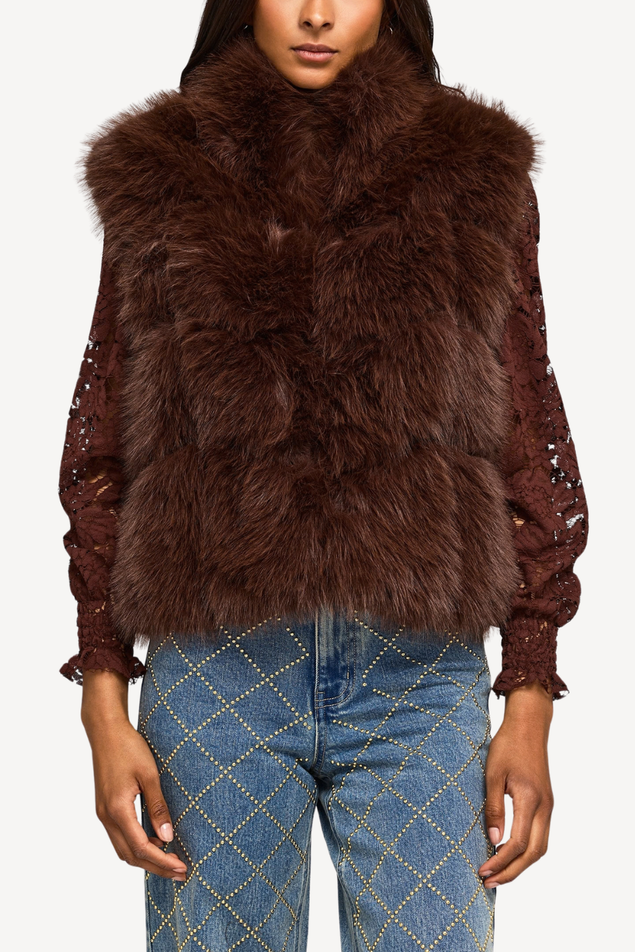 faux fur brown vest with brown lace long sleeve underneath and sparkled pattern jeans 