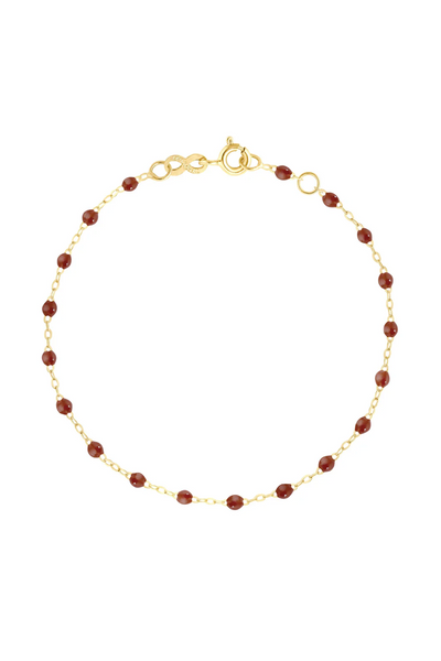 Gold bracelet with moka beads on a white background