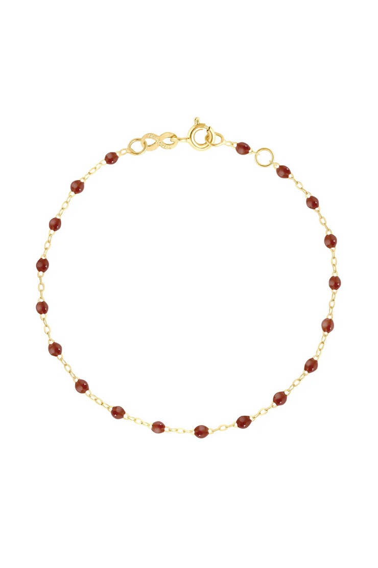 Gold bracelet with moka beads on a white background
