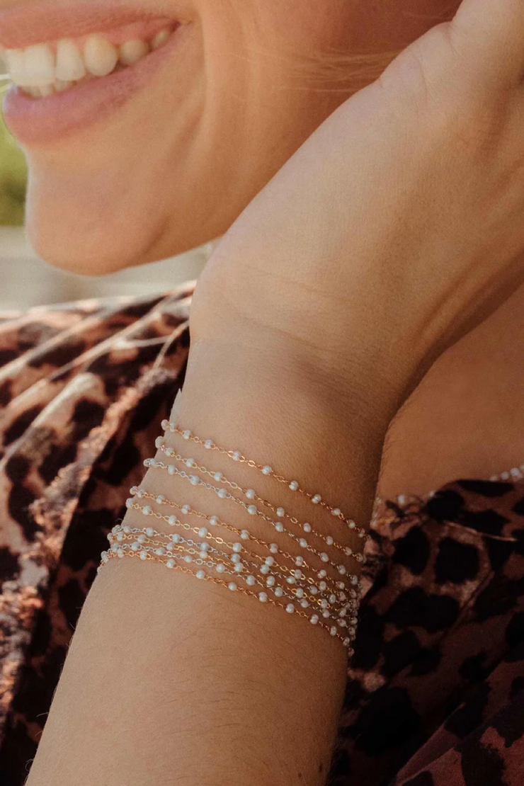 Close-up of a person wearing a delicate bracelet with a blurred background