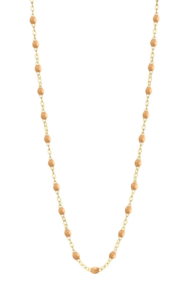 Necklace with nude beads on a gold chain against a white background