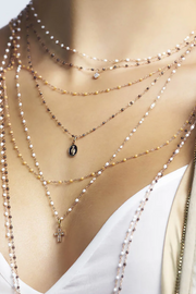 Woman wearing multiple layered necklaces with visible pendants