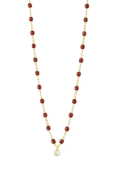 Necklace with moka beads, 1 diamond  and a gold chain on a white background 