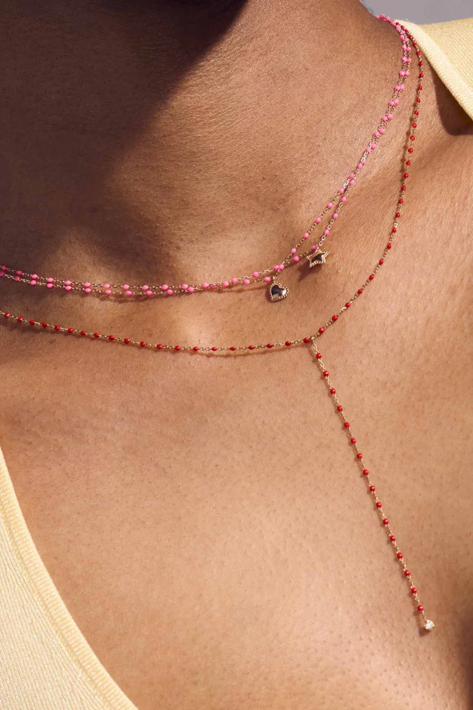 Close-up of a person wearing a delicate pink beaded necklace.