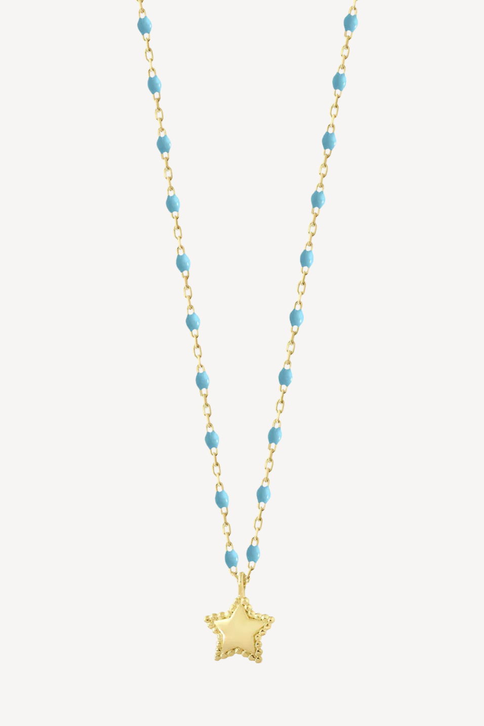 Necklace with blue beads and a gold star pendant on a white background