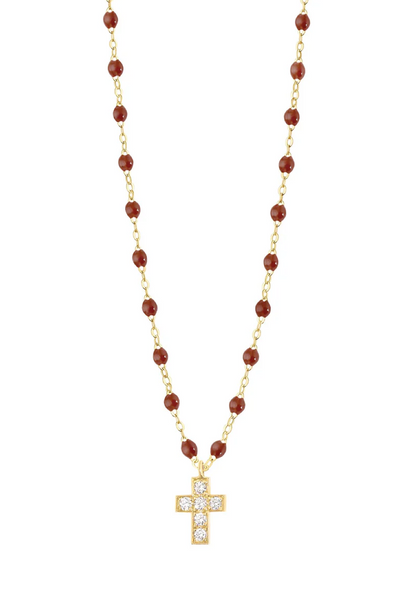 Gold necklace with moka beads and a cross pendant on a white background