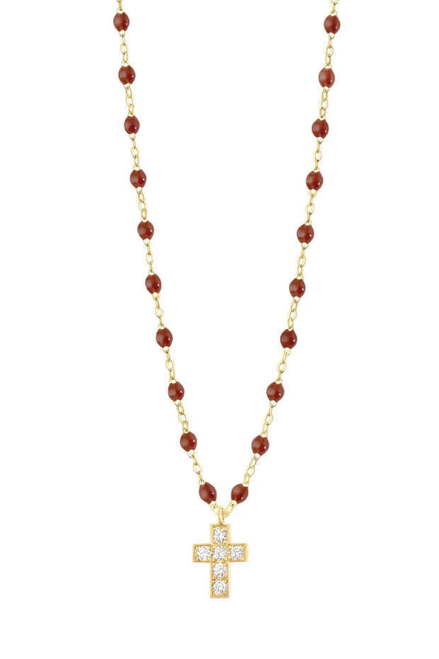 Gold necklace with moka beads and a cross pendant on a white background