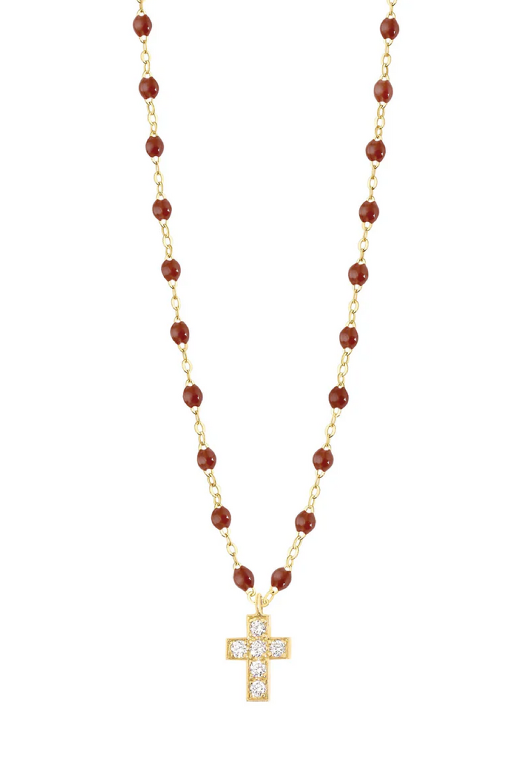 Gold necklace with moka beads and a cross pendant on a white background