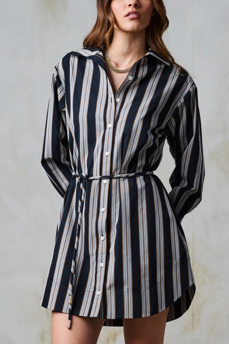 Woman wearing a black and white striped dress against a neutral background