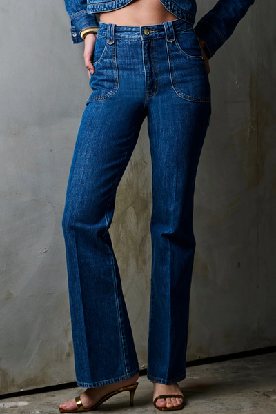 Person wearing blue jeans against a plain background