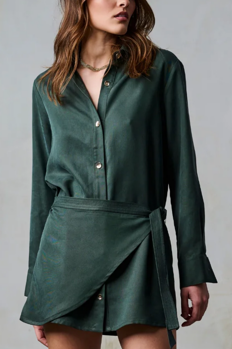Woman wearing a green dress with a plain background