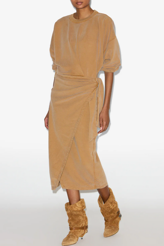 Person wearing a caramel dress and matching boots on a white background