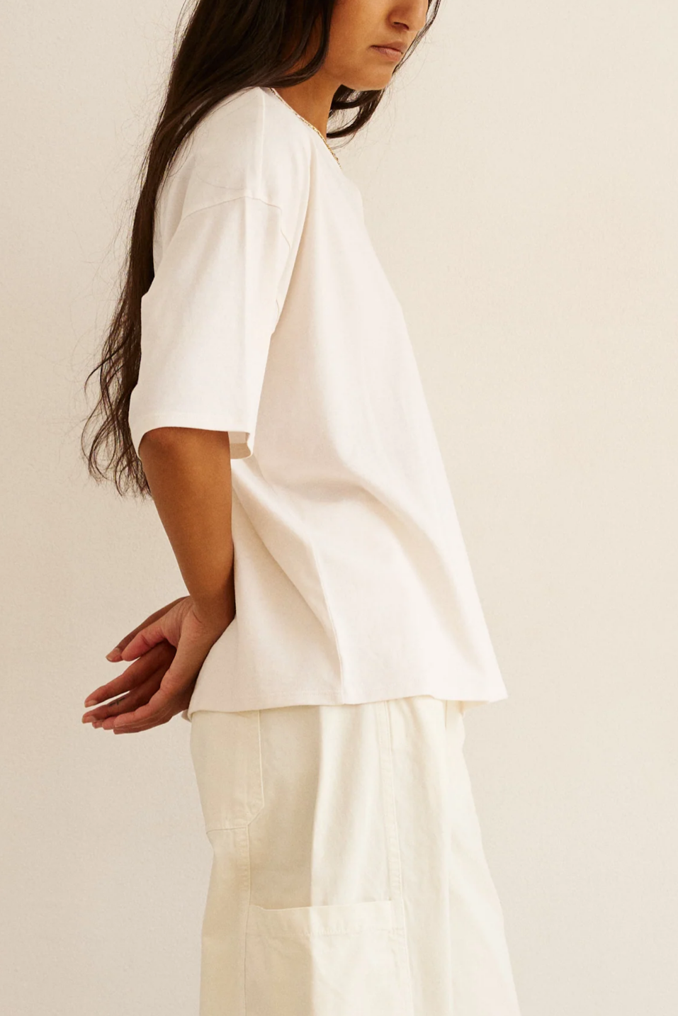 Person wearing a white outfit against a plain background