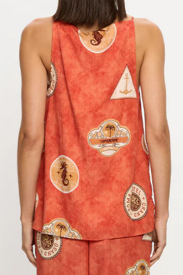 Person wearing a red sleeveless top with decorative patterns on a white background