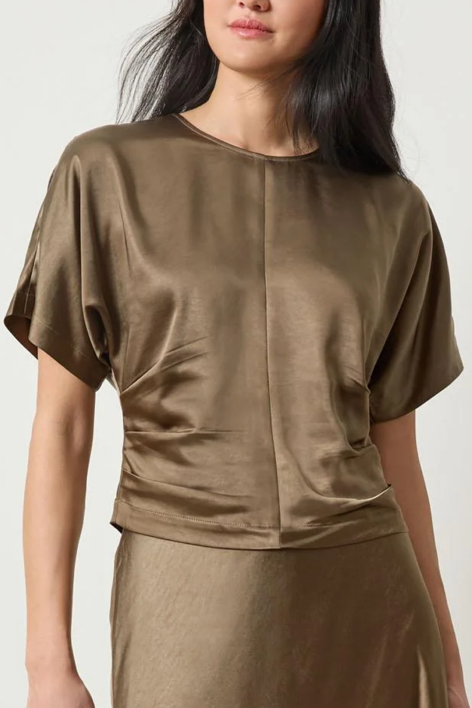 Woman wearing a parsley top and skirt set against a white background