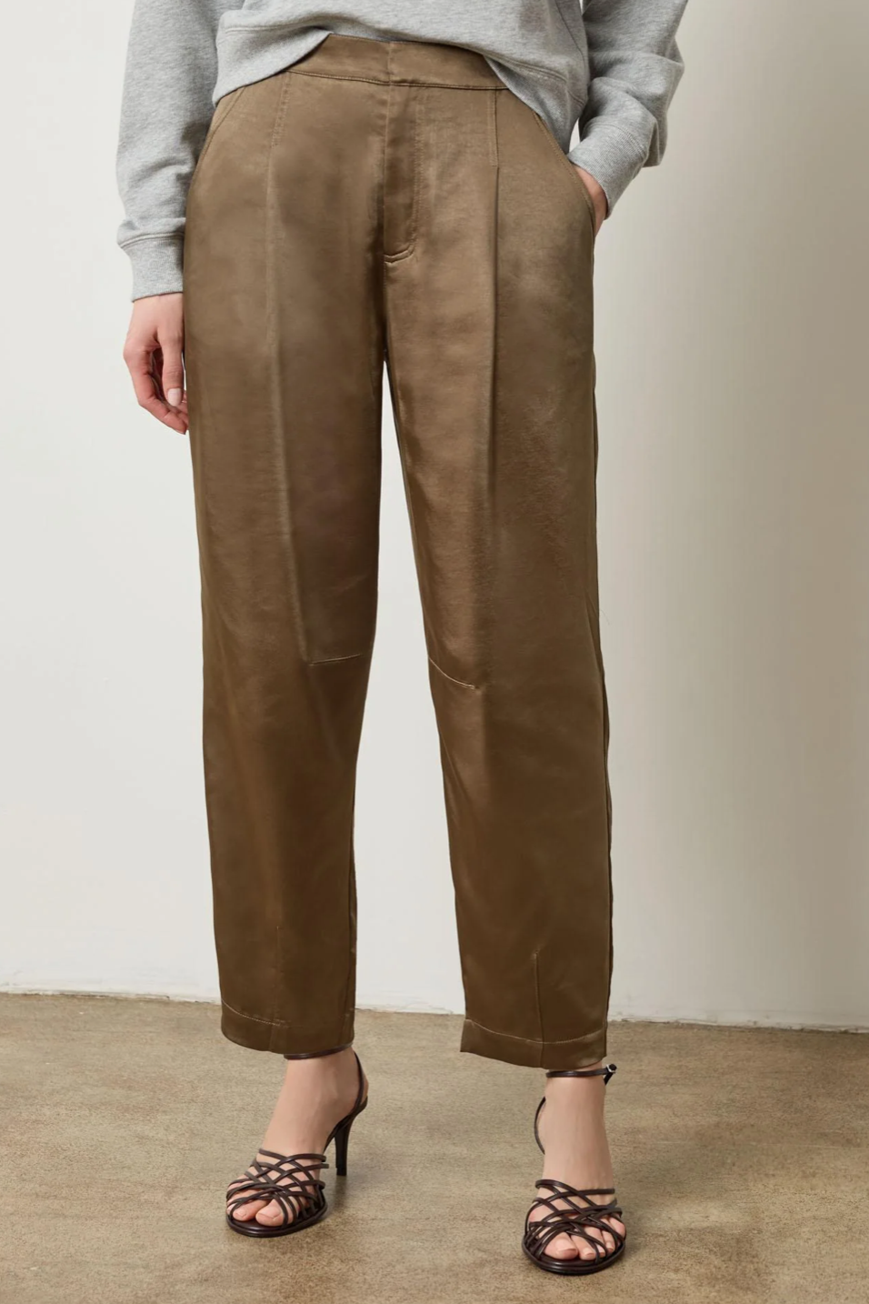Person wearing parsley pants and a gray top against a plain background