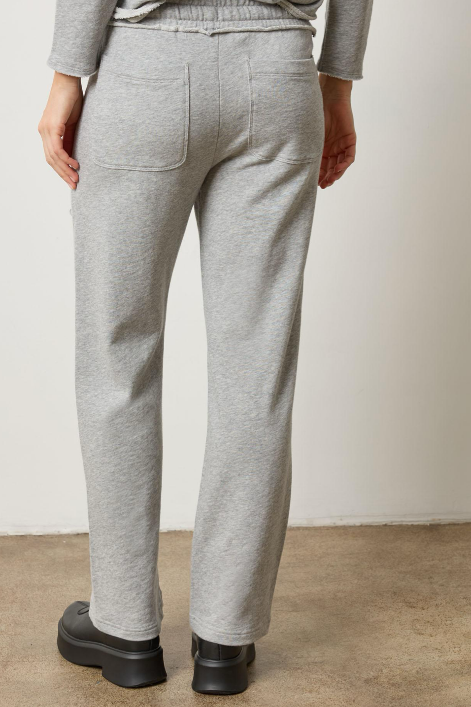 Person wearing gray sweatpants on a plain background