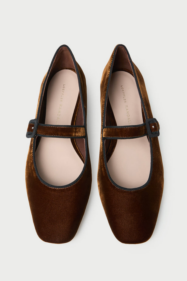 Pair of brown velvet shoes with a strap on a white background