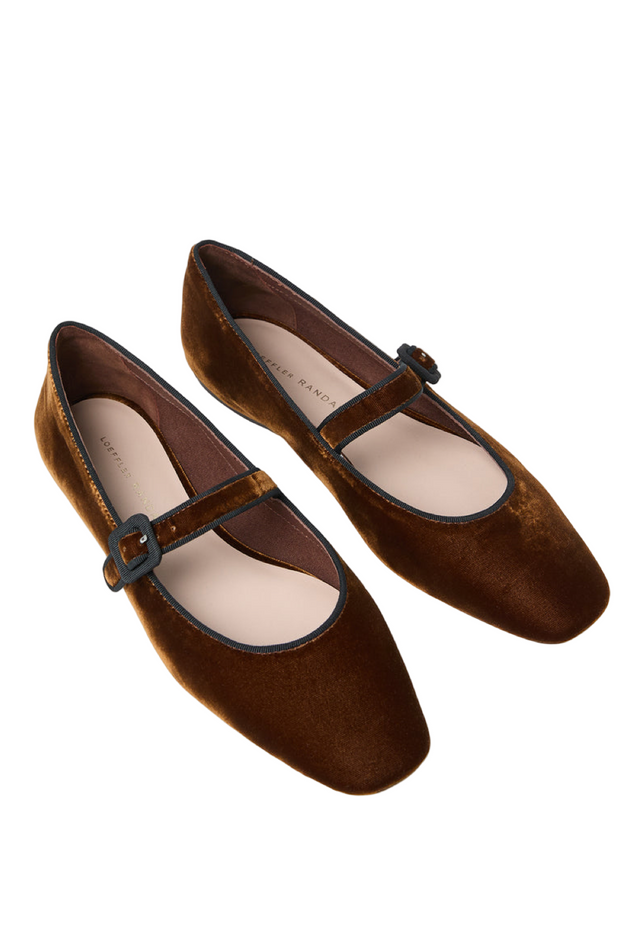 Pair of brown suede shoes with a strap on a light gray background