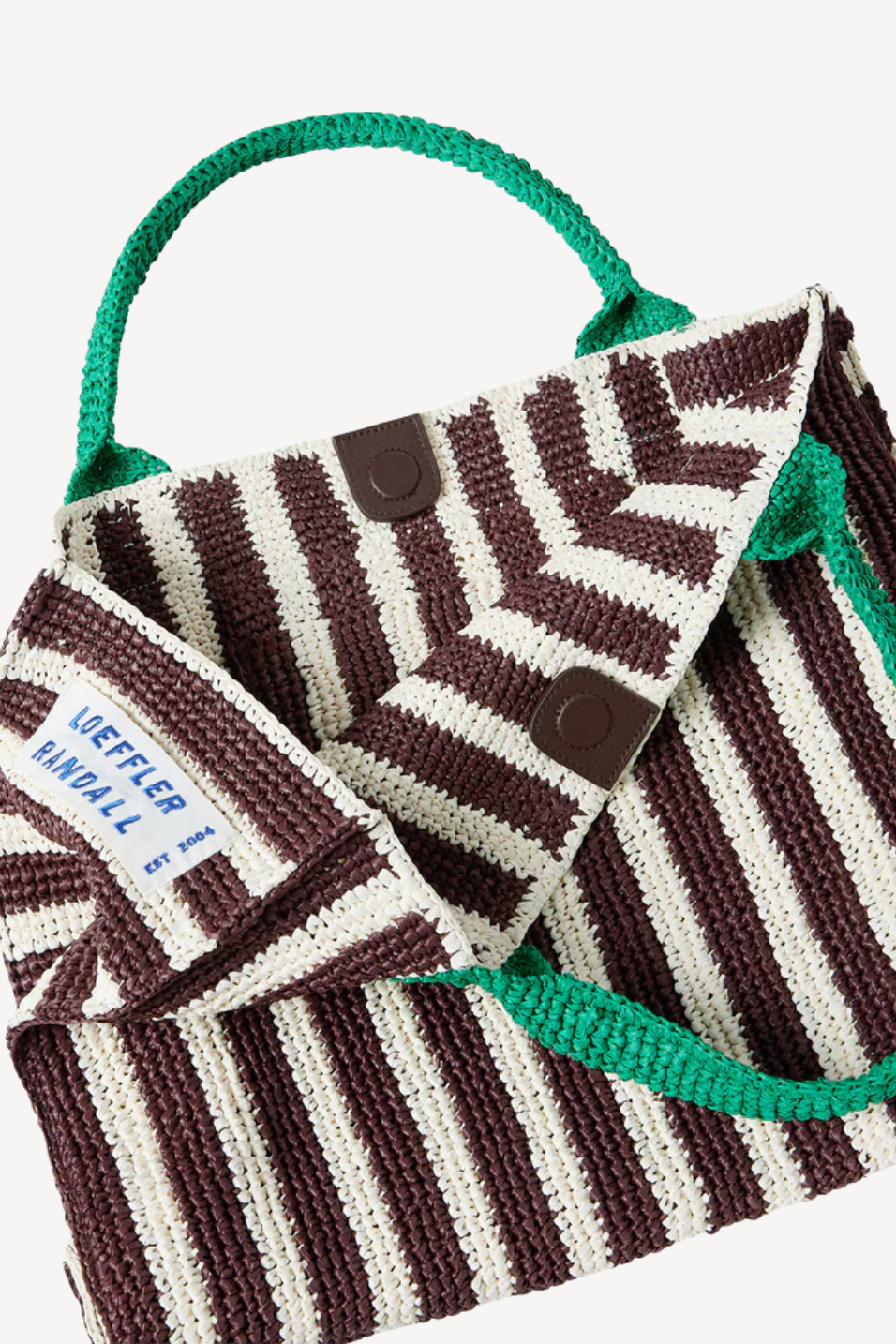 Knitted bag with brown and white pattern and green handle on a white background