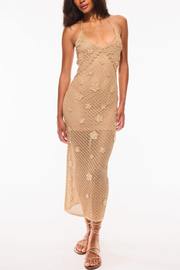 Woman wearing a beige lace dress on a white background