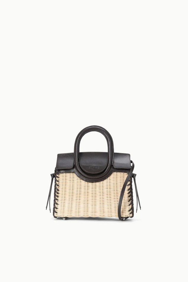 Handbag with woven design and black top handle on a white background