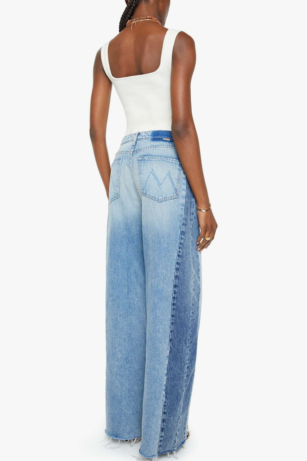 Person wearing a white top and blue jeans on a white background