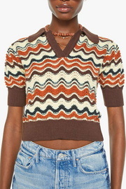 Person wearing a patterned sweater with short sleeves and jeans on a white background