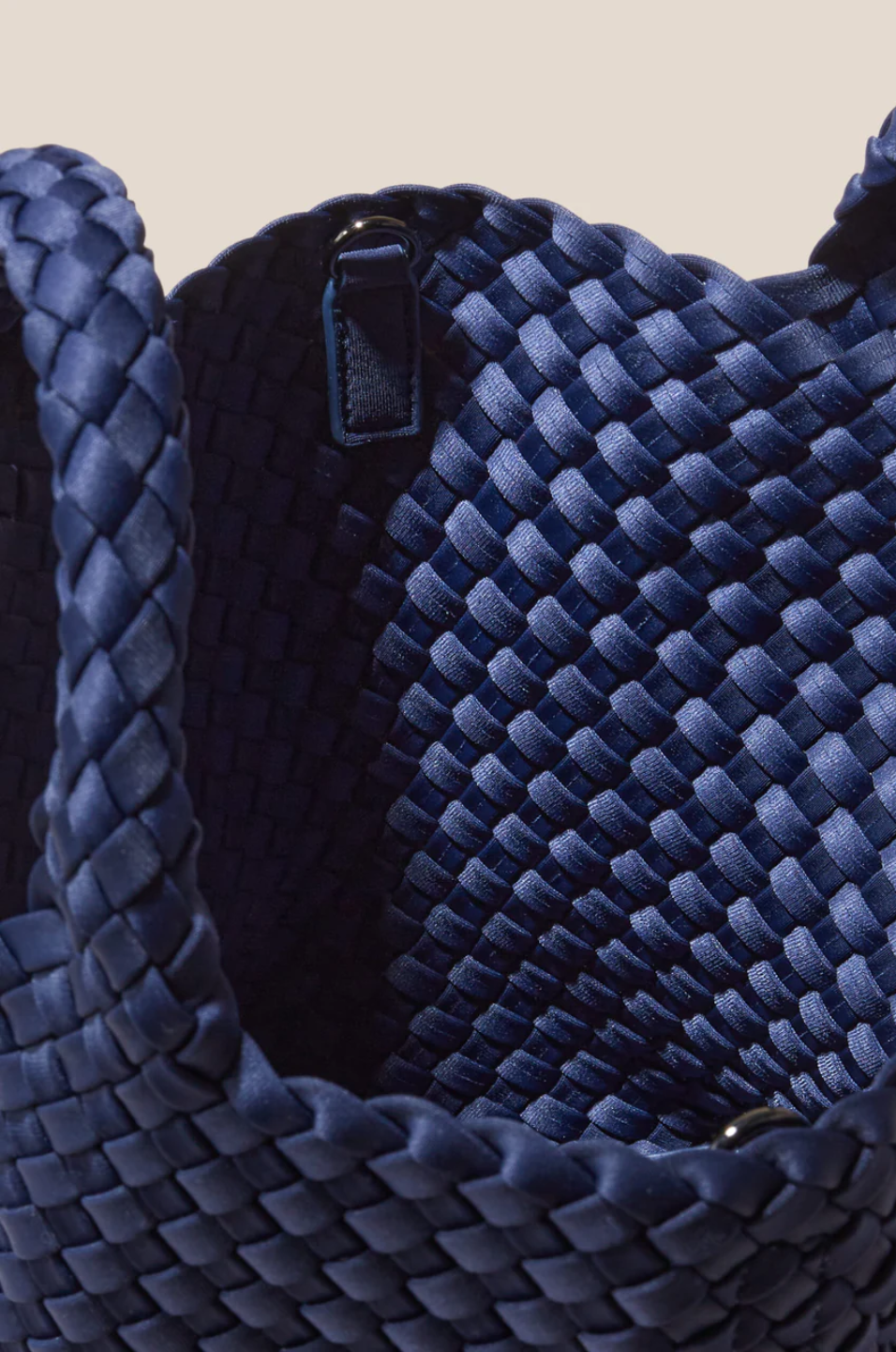 Close-up of a blue woven handbag with a beige background