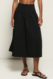 Black skirt worn by a person on a white background