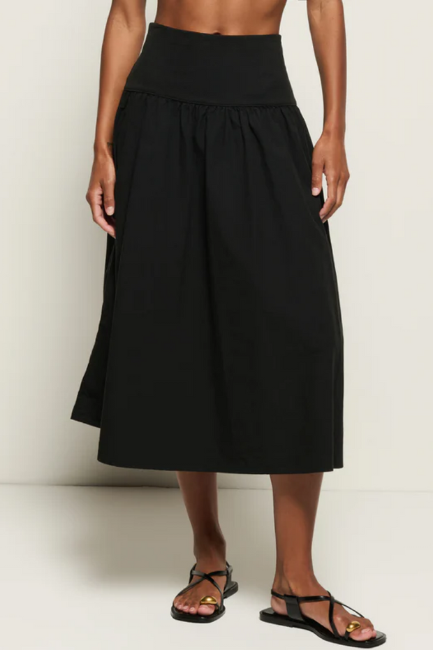 Black skirt worn by a person on a white background