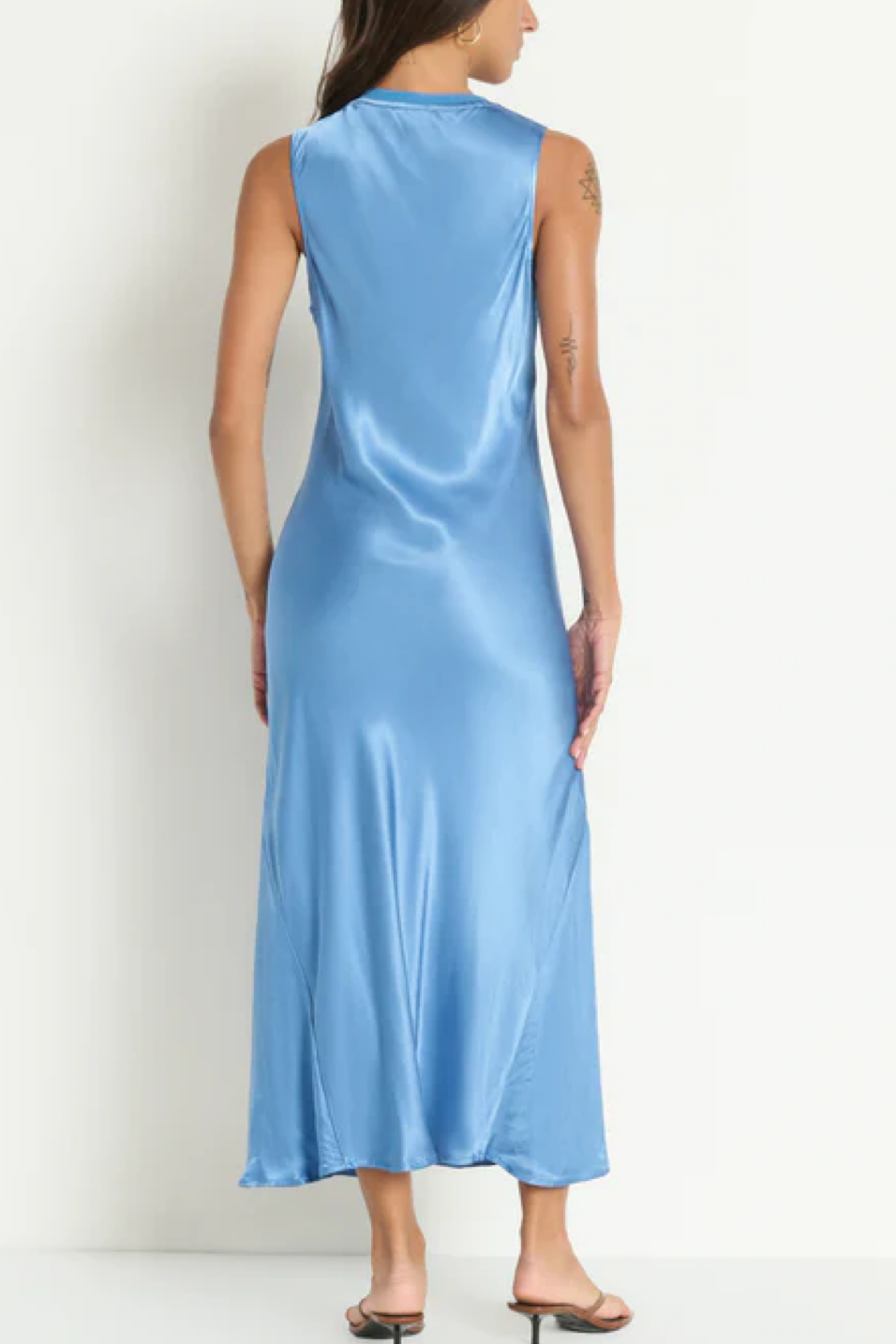 Woman wearing a light blue satin dress against a white background