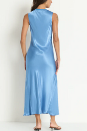 Woman wearing a light blue satin dress against a white background