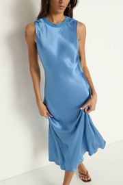Woman wearing a blue sleeveless dress against a white background