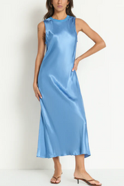 Woman wearing a light blue satin dress against a white background
