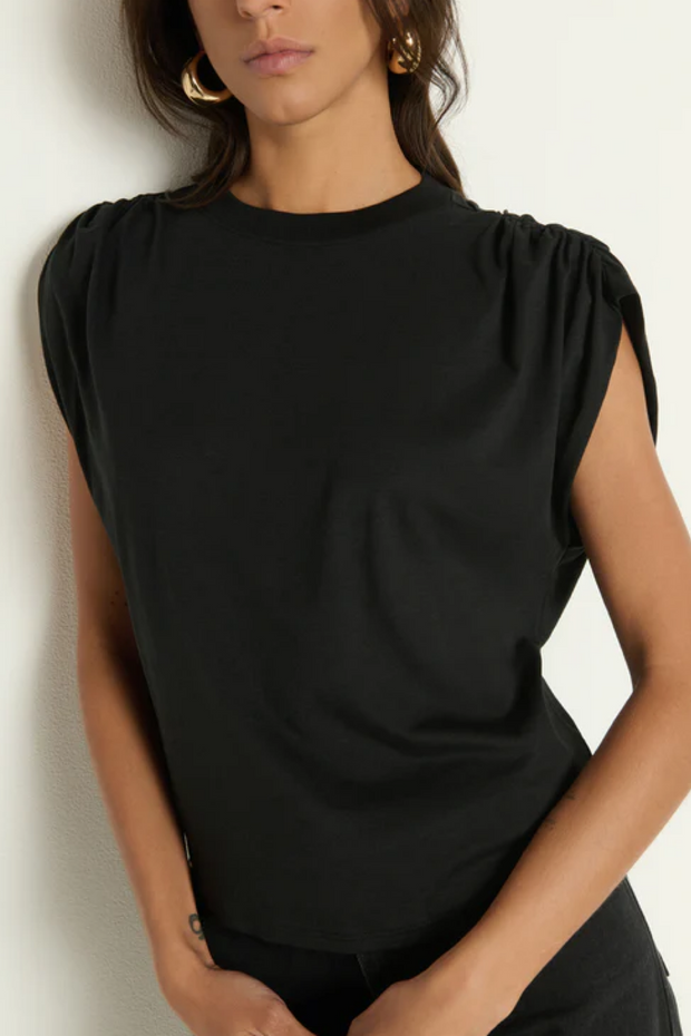 Woman wearing a black sleeveless top against a plain background