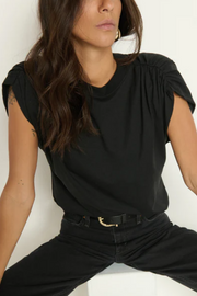Woman wearing a black top and black pants against a white background
