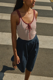 Woman wearing a striped tank top and navy skirt on a zebra crossing