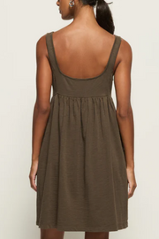 Woman wearing a brown dress with a plain background
