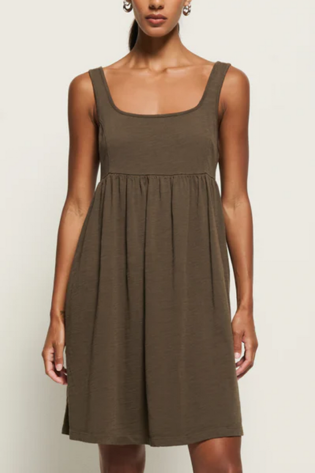 Woman wearing a brown dress against a plain background