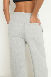 Gray sweatpants worn by a person on a white background